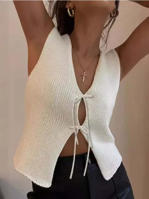 Stylish woman in a white knit top with a front tie, showcasing effortless charm and bold fashion.