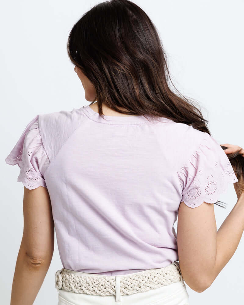 Back view of a woman wearing a lavender Lovely Eyelet Tee with delicate eyelet sleeve details from Downeast.